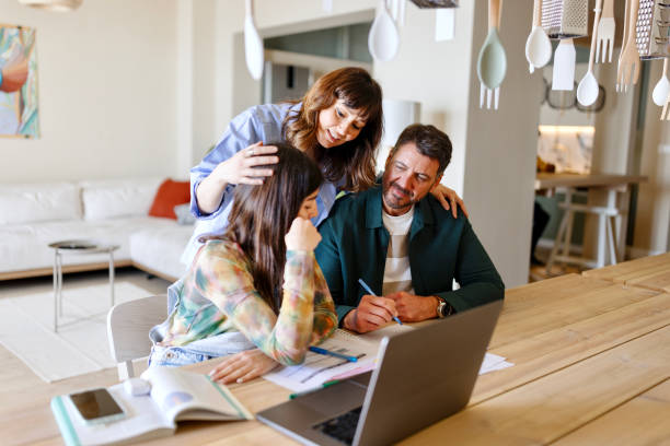 istock Loving parents helping their daughter with her school project 1555842748