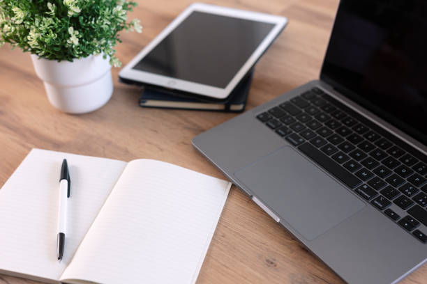istock Wooden table with office supplies, top view 1555844525