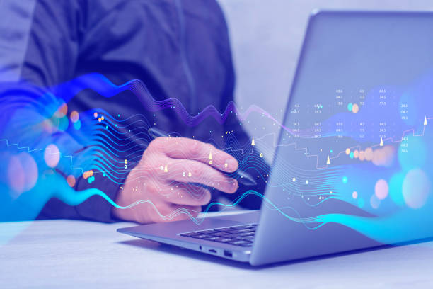 istock Businessman with laptop analyzes financial market data. Futuristic technology solution for business development. Abstract technological background in vibrant colors with blur. 1555845120