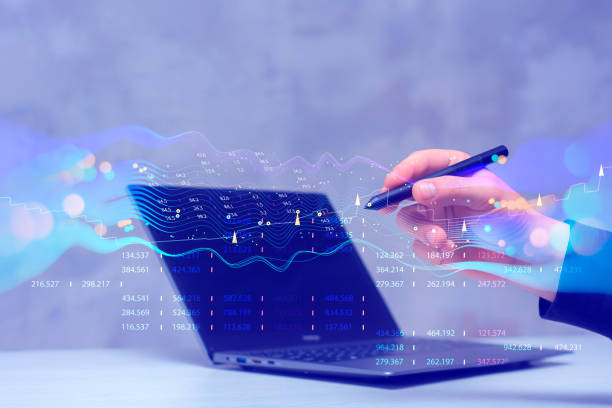 istock Businessman with laptop analyzes financial market data. Futuristic technology solution for business development. Abstract technological background in vibrant colors with blur. 1555845121