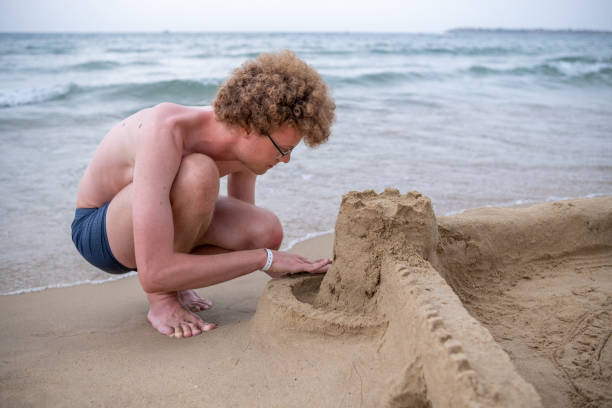 istock A big boy is building a sandcastle on the beach. 1555850928