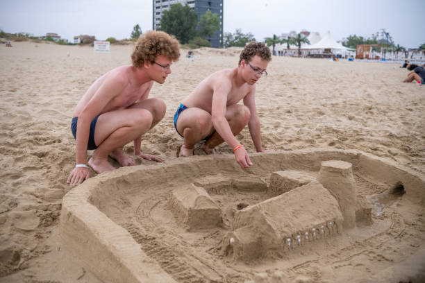 istock Two boys are building a sandcastle on the beach. 1555851494