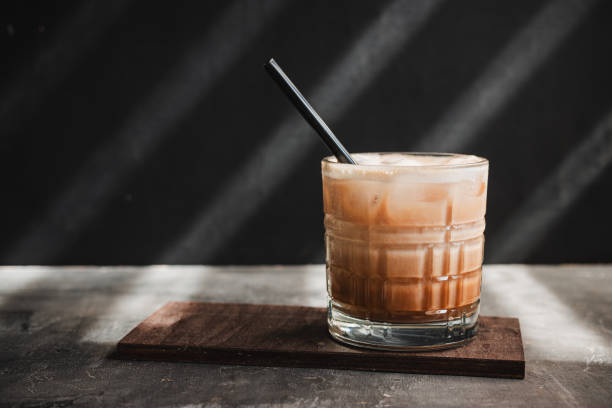 istock Ice latte coffee drink in a glass with a straw on dark background, summer refreshment drink 1555895166