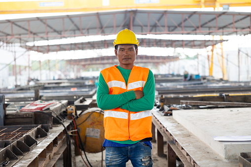 Armcrossed. Portrait Asian professional Engineer factory. Engineering worker in safety hardhat at factory industrial facilities. Heavy Industry Manufacturing Factory. Prefabricated concrete walls