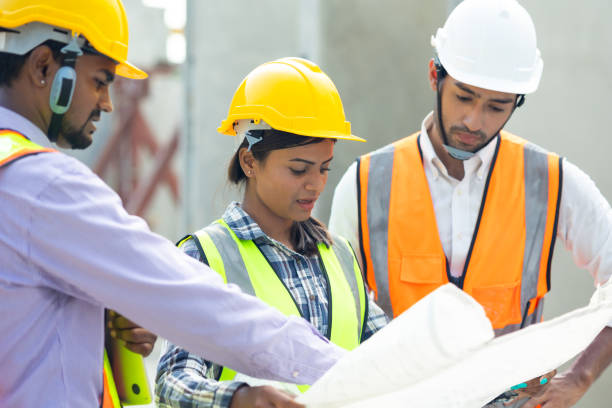 istock Professional Mechanical Engineer team Working on construction blueprints paper at Prefabricated concrete factory Heavy industrial. Product quality Inspection. Unity and teamwork concept 1555916240