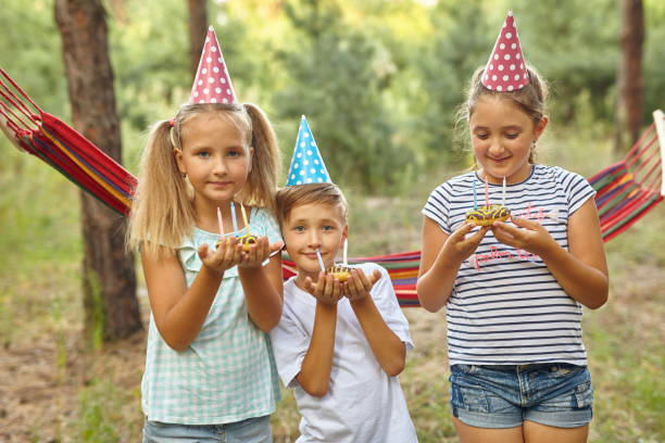 istock Children holding birthday cakes with burning candles. 1555917425