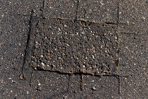 Damaged asphalt pavement , close up of a damaged and defective road