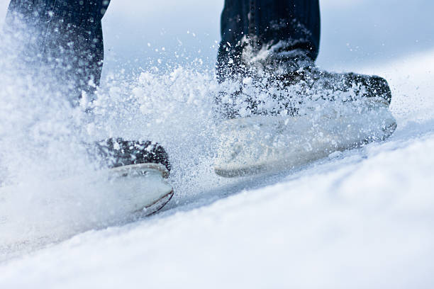 Two breaking ice skates with flying snow stock photo