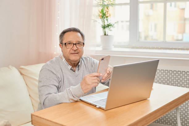 istock Cheerful senior man has phone conversation from home. 1555929205