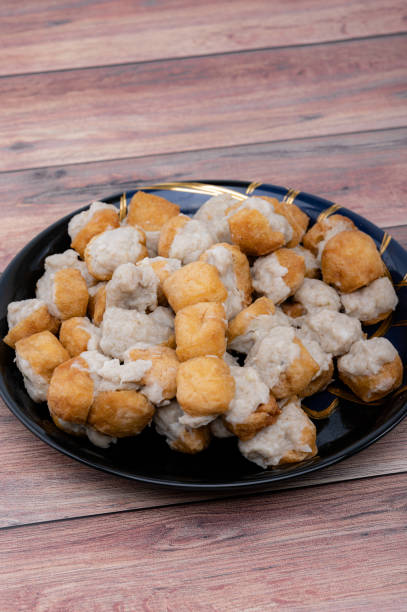 istock Fried Fish Tofu placed in a black plate and put on the wooden table. 1555940096