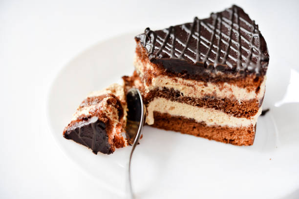 istock Chocolate cake on a white plate. A cake and a spoon. Eating sweets. 1555947120