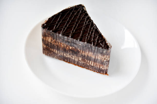 istock Chocolate cake on a white plate. A sweet snack. Sweetness for tea. 1555947121