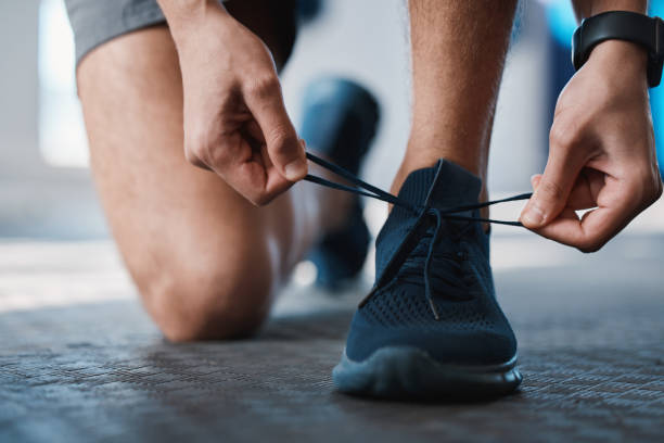 피트니스, 신발, 넥타이는 체육관에서 유산소 운동이나 지구력 운동을 준비하는 스포츠맨과 함께합니다. 훈련, 달리기 및 훈련 시작시 남성 운동 선수 또는 주자의 끈으로 준비 - mens track 이미지 뉴스 사진 이미지