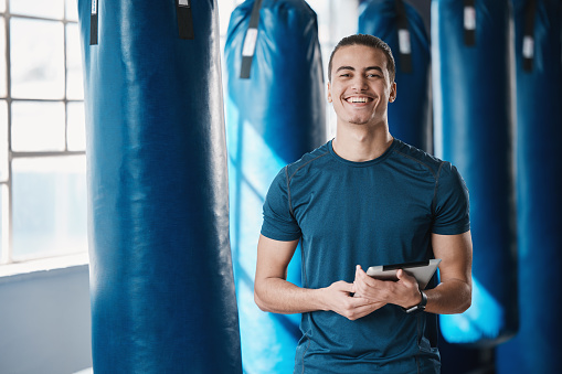 Fitness, man and gym coahc with tablet ready for exercise class and training with a smile. Young male person, athlete and wellness center for personal trainer happy from workout with digital app
