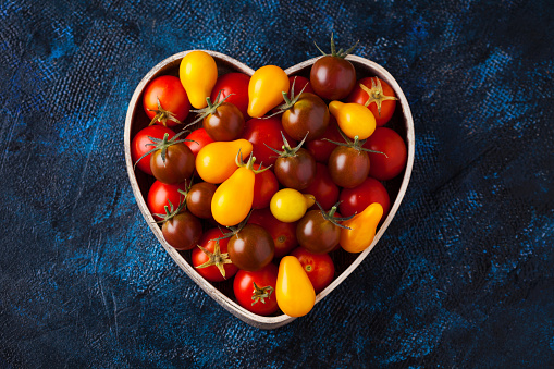 fresh delicious tomatoes in heart-shape bowl - fruits and vegetables