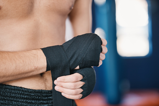 Fitness, boxing and man wrap hands with abdomen closeup in gym for training, workout and exercise. Sports, body builder and stomach of male athlete ready for boxer competition, practice and mma fight