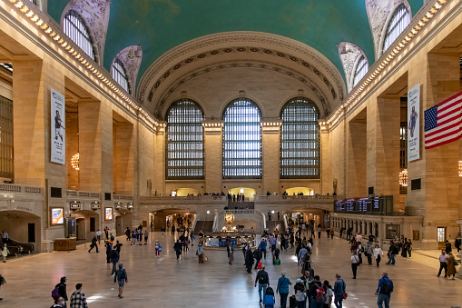 New York City, NY, USA-April 2022; High angle view of the interior of the main hall of Grand Central Terminal busy with people and iconic clock in middle of the floor