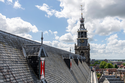 Gouda, The Netherlands-June 2022; View along the roof with church bell tower and people walking of St John's Church during roof walking tour during 750 year celebration city rights