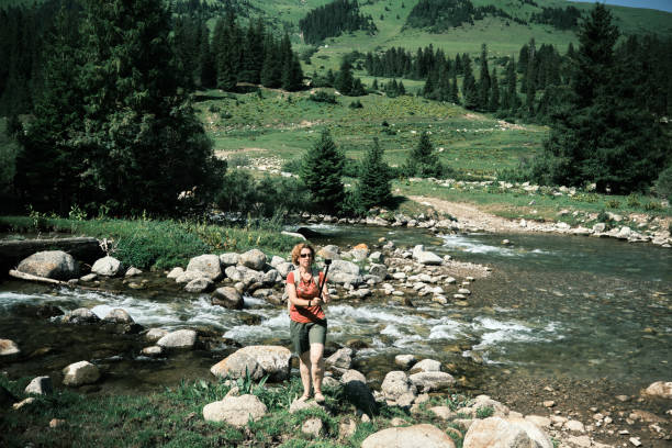 45-years old female tourist is vlogging next to mountain river