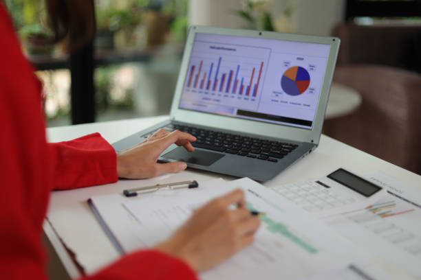 istock Businesswoman working with laptop on desk typing and analyzing financial data. 1555963712