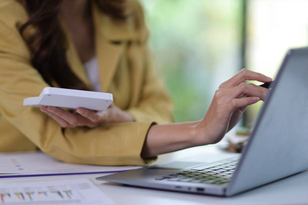istock Businesswoman working with laptop on desk typing and analyzing financial data. 1555964253