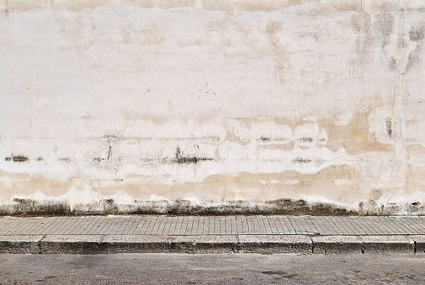 old concrete grunge wall with sidewalk - wall stockfoto's en -beelden