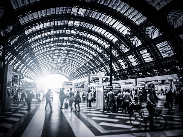 Activity in Milan Central Station, Italy Activity in Milan Central Station, Italy. Tilt shift effect and little of grain added for the mood. train station black and white stock pictures, royalty-free photos & images