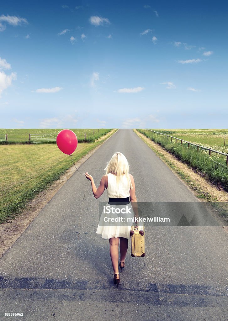Женщина гуляет, в то время как держит шар и Чемодан - Стоковые фото Женщины роялти-фри