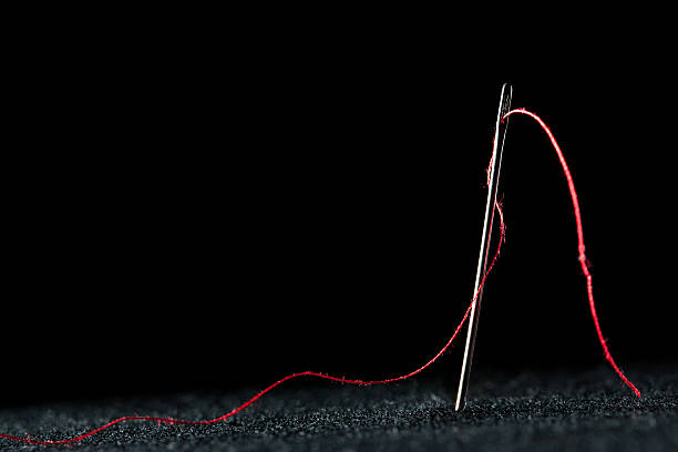 Needle and red thread Needle and red thread sewing needle photos stock pictures, royalty-free photos & images