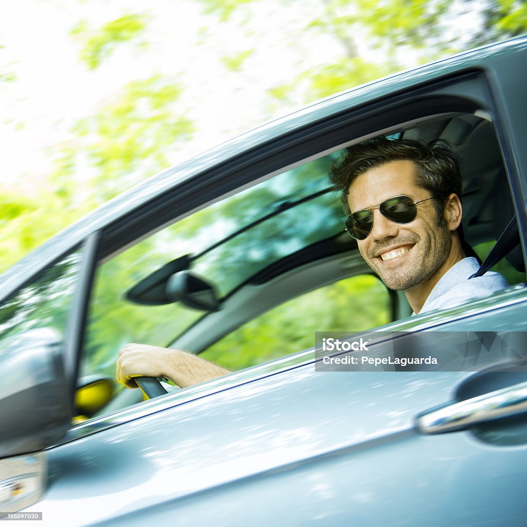 Middle age man driving a car Middle age man driving a car in a green forest. Driving Stock Photo