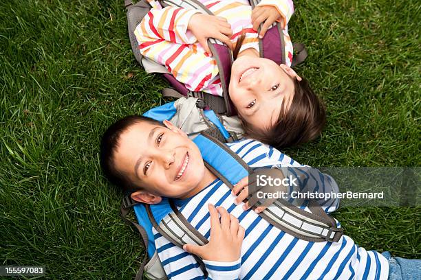 Młody Chłopiec I Dziewczynka Leżąc Na Trawie W Szkole - zdjęcia stockowe i więcej obrazów Powrót do szkoły