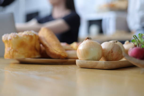 Close up onion in kitchen and young woman cooking.