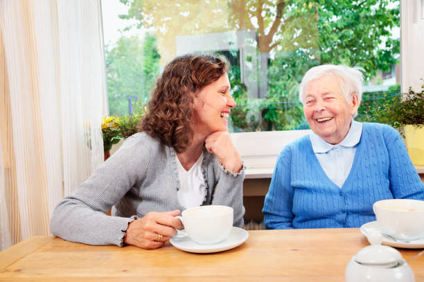 istock Caregiver drinking coffee with a senior woman 155597276