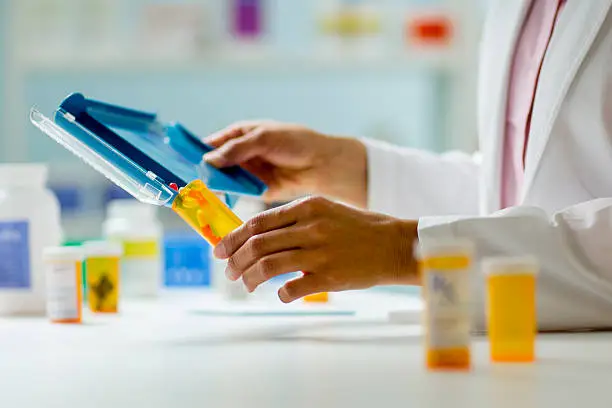 Photo of Pharmacy Hands with Pill Counter Tray and Bottle