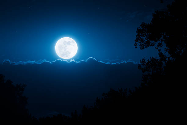 This bright, shining moonrise illumintates the night time sky wth the brilliance of the sun as it rises above a cloud bank.