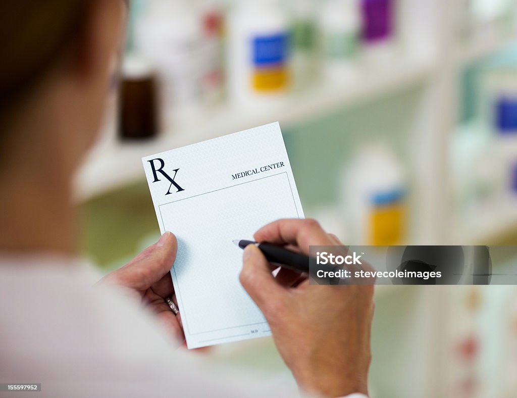 Prescription Pharmacist filling out RX form Adult Stock Photo