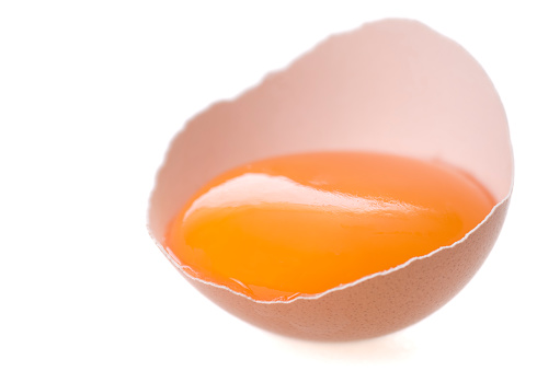 A brown egg, broken with egg yolk. Isolated on white