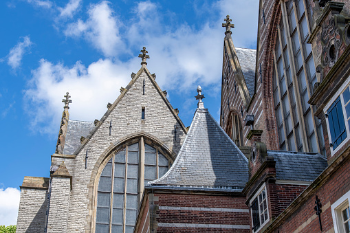 Low angle view of building and roof structures of St John's Church in Gouda, The Netherlands, the longest church in the Netherlands with 16th-century stained-glass