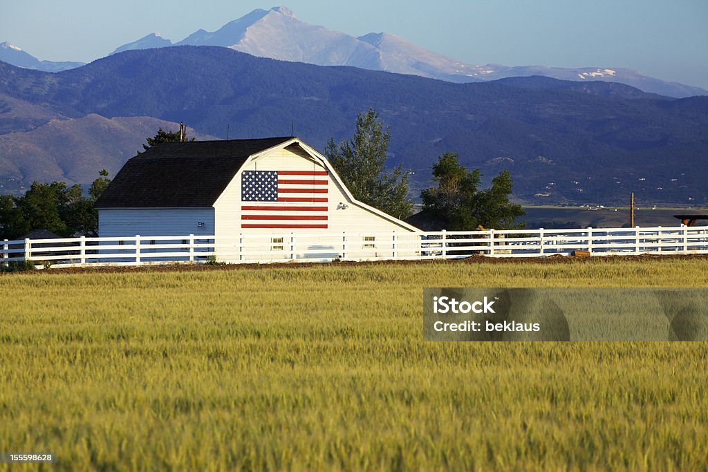 Bandera estadounidense en Barn en montañas rocosas - Foto de stock de Bandera estadounidense libre de derechos