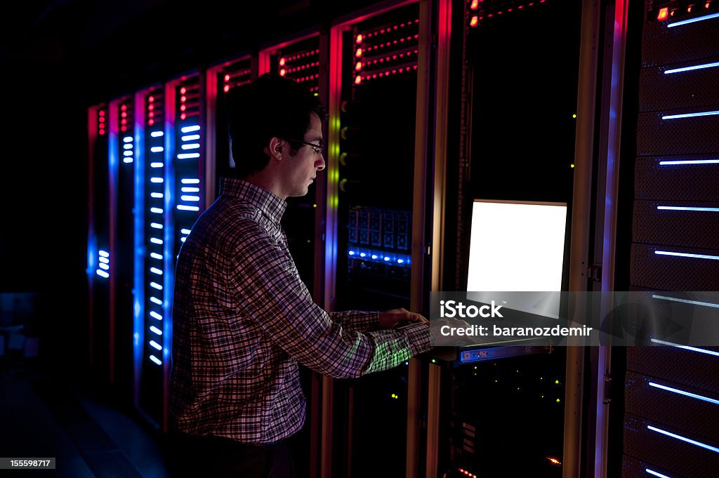 IT Engineer in Action Configuring Servers Modern interior of server room in datacenter. IT Engineer in Action Configuring Servers Network Server Stock Photo