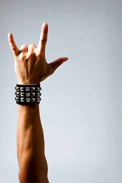 Photo of Man in Wristband making Rock & Roll Hand Symbol