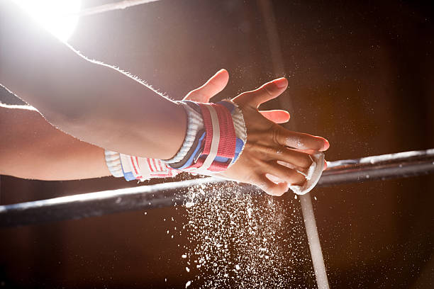 Chalk Power Falls from Hands as Gymnast Preps for Bars  sports chalk stock pictures, royalty-free photos & images