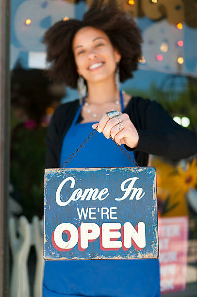 donna con open-segnale inglese - small business business owner facade foto e immagini stock