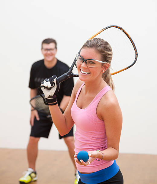 Racquetball Man and woman playing racquetball on court. racketball stock pictures, royalty-free photos & images