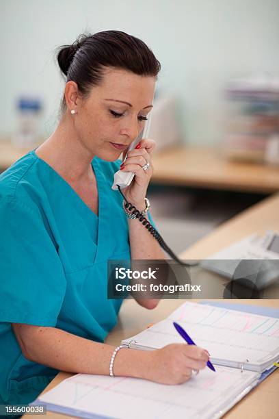 Enfermera Escribe Una Cita En El Calendario Foto de stock y más banco de imágenes de Usar el teléfono - Usar el teléfono, Recepcionista, Organizador personal
