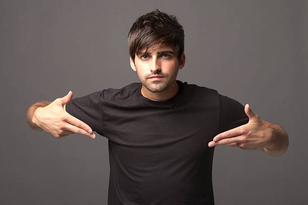 Handsome young man pointing at blank black shirt