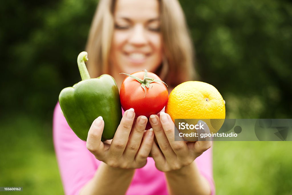 Młoda kobieta Trzymając owoce i warzywa - Zbiór zdjęć royalty-free (Jabłko)