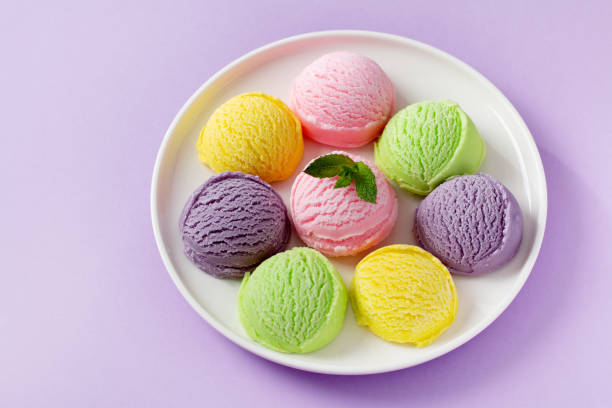 istock Pastel colored ice cream scoops on white plate, top view. 1556001620