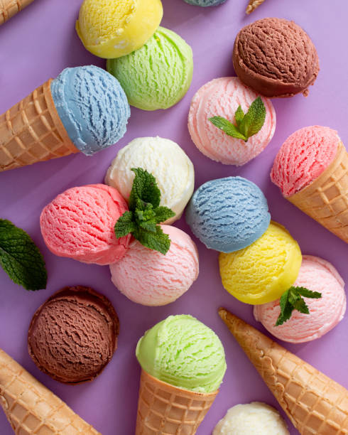 istock Pastel colored ice cream scoops and cones background on pastel violet 1556001632