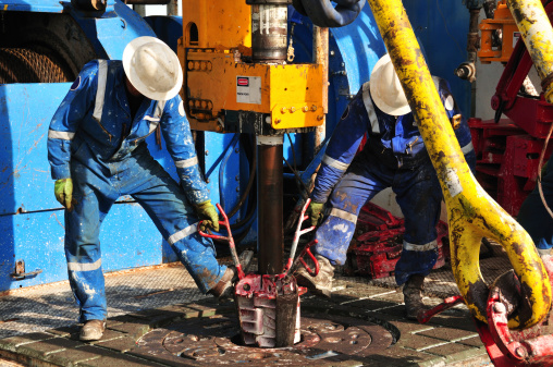 Drilling rig workers preparing to make a connection during drilling operation.